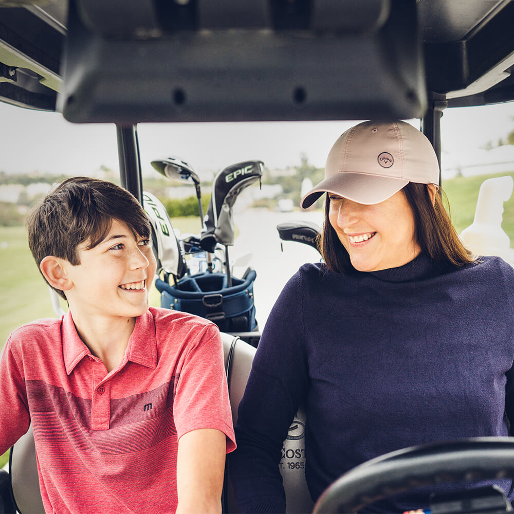 Image of child and adult in golf cart